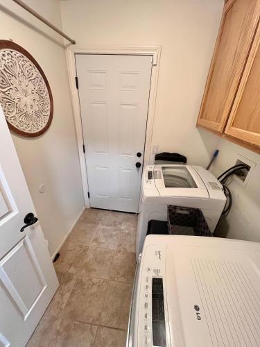 a laundry room with a washer and dryer next to a door at The Joshua Tree House in Joshua Tree