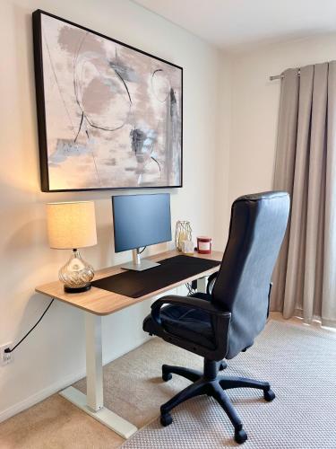 a desk with a chair and a computer monitor at The Joshua Tree House in Joshua Tree