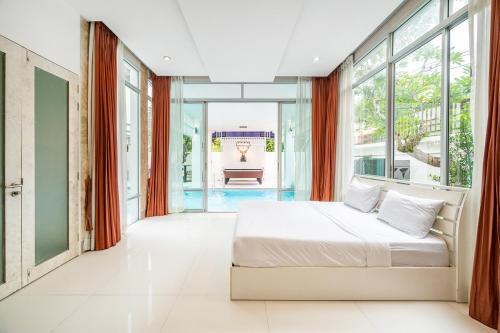 ナ・ジョムティエンにあるMagenta Grand House Pool Villa Pattayaのベッドと大きな窓のある寝室