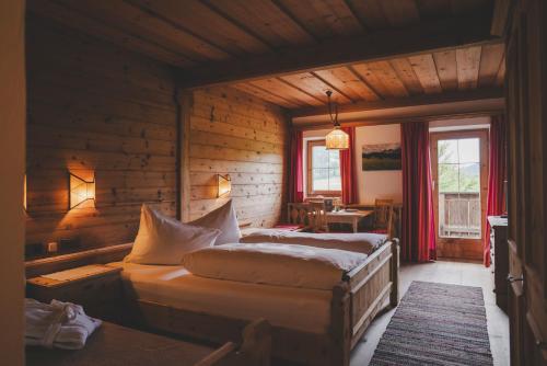a bedroom with two beds in a wooden room at Demeterhof Knolln in Söll
