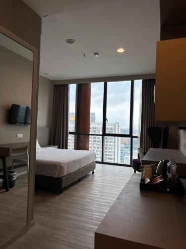 a hotel room with a bed and a large window at QQ Empire Damansara hotel room in Petaling Jaya