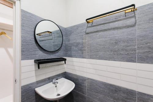 a bathroom with a sink and a mirror at Urbanview Hotel Ivoeira House Lampung By RedDoorz in Hajimana