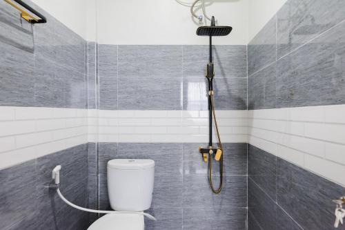 a bathroom with a shower with a toilet in it at Urbanview Hotel Ivoeira House Lampung By RedDoorz in Hajimana