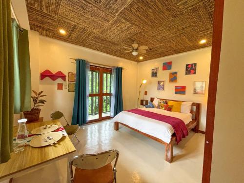 a bedroom with a bed and a table and a table sidx sidx sidx at Copacabana Siargao in General Luna