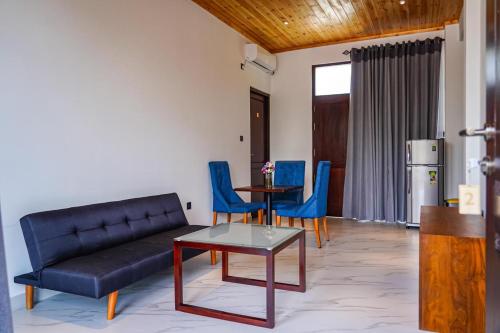 a living room with a couch and a table and chairs at Clear Point Studio in Dickwella