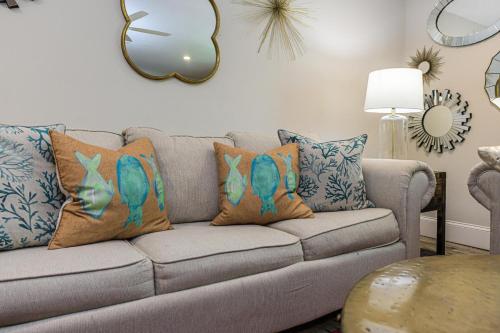 a living room with a couch with pillows on it at Blissful Bay at Bayside Bungalow in Anna Maria