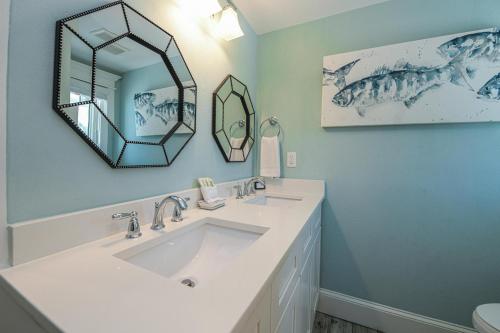 a bathroom with a sink and a mirror at Blissful Bay at Bayside Bungalow in Anna Maria