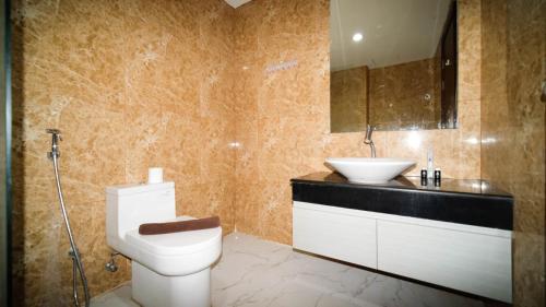 a bathroom with a toilet and a sink at Modern and Cozy 1BR at Grand Sungkono Lagoon Apartment By Travelio in Surabaya