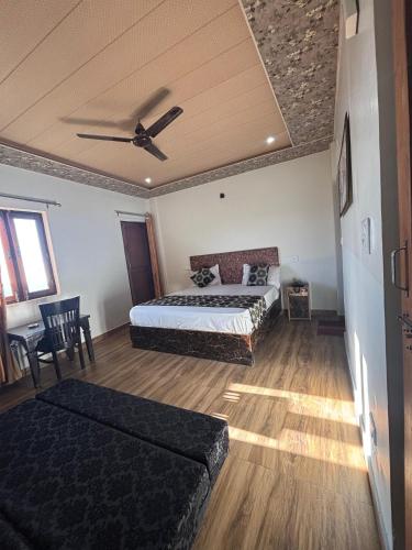 a bedroom with two beds and a ceiling fan at Baakhli Guest House and Restaurant in Bhowāli