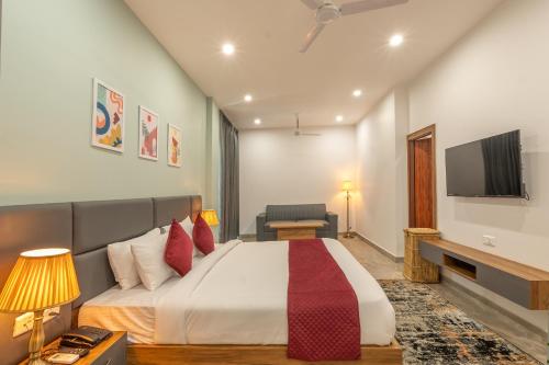 a hotel room with a bed and a tv at Corbett Tusker Meadows by White Flower in Rāmnagar