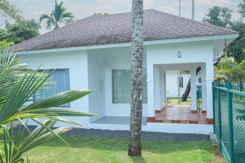 a white house with a fence in front of it at Arayaal Serviced Villa in Champakulam