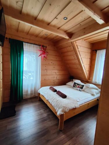 a bedroom with a bed in a wooden house at U Dziadka in Chochołów
