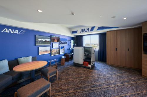 a room with a couch and a table and a tv at Villa Fontaine Grand Haneda Airport in Tokyo