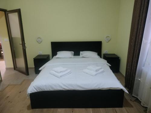 a bedroom with a large bed with white sheets at Casa Albert Litman in Sinaia