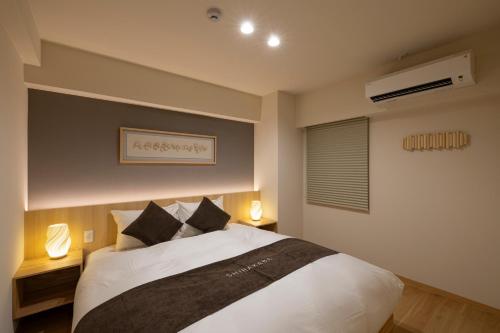 a bedroom with a large bed with two lamps at Shirakabanoyado-KI NO NOKI, 白樺の宿-木の軒, SELF CHECK-IN in Osaka