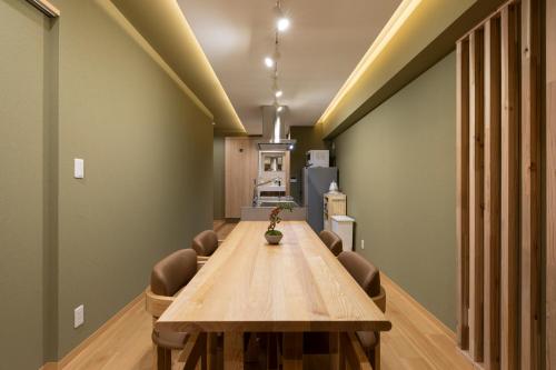 a conference room with a long wooden table and chairs at Shirakabanoyado-KI NO NOKI, 白樺の宿-木の軒, SELF CHECK-IN in Osaka