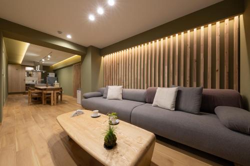 a living room with a couch and a table at Shirakabanoyado-KI NO NOKI, 白樺の宿-木の軒, SELF CHECK-IN in Osaka