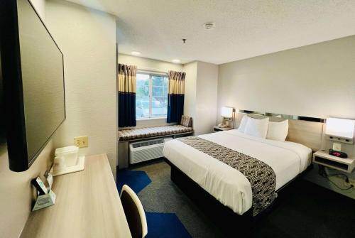 a hotel room with a bed and a television at Microtel Inn Georgetown - Lexington North in Georgetown