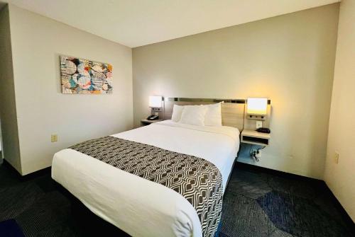a hotel room with a large bed and two lamps at Microtel Inn Georgetown - Lexington North in Georgetown