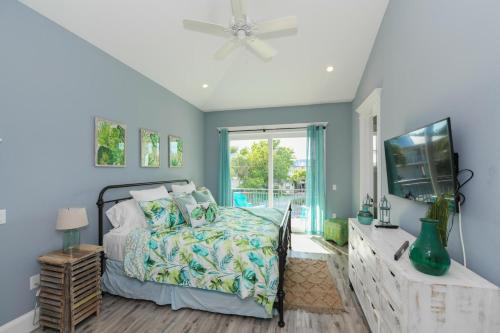een slaapkamer met een bed en een flatscreen-tv bij Daiquiri Deck in Anna Maria