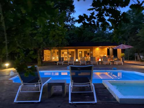 - deux chaises et une piscine la nuit dans l'établissement Les Maourelles, à Grayan-et-lʼHôpital