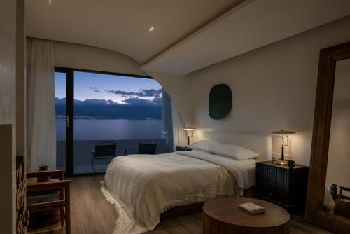 a bedroom with a large bed and a large window at 大理空岛半山海景民宿 in Dali