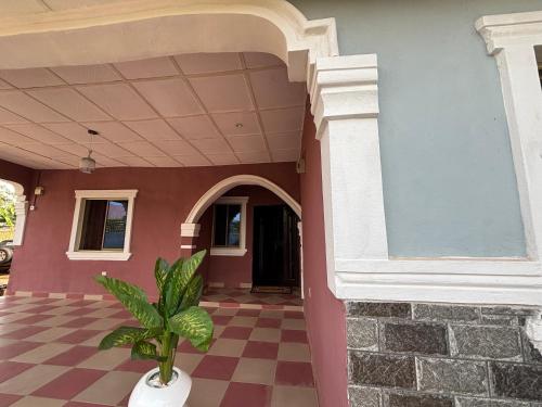 a house with a potted plant on a checkered floor at The Republic Guesthouse in Otta