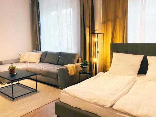 a living room with a bed and a couch at 70qm Apartment in Viersen zentral gelegen mit hohen Decken - BEUYS Apartments - Viersen in Viersen