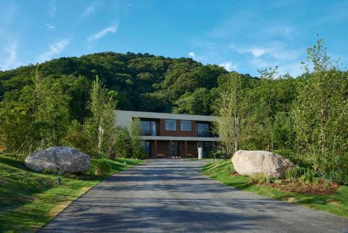 a house with two large rocks on the side of a road at HACIENDA VISON hotel in Odaicho