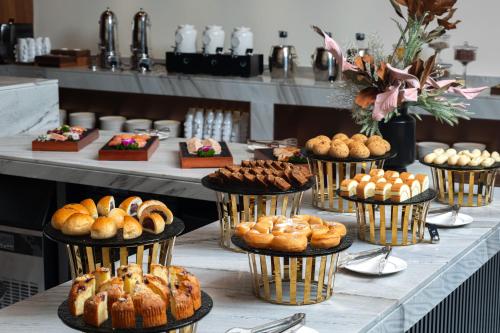 uma mesa cheia de diferentes tipos de pastelarias e bolos em 深圳南山万象青华酒店 em Shenzhen