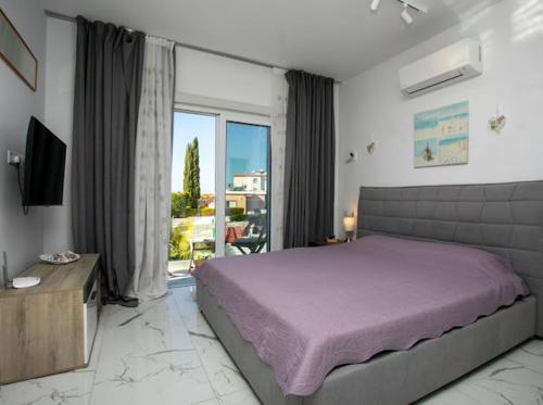 a bedroom with a large bed and a large window at Villa Valendra in Peyia
