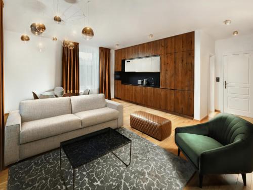 a living room with a couch and a chair at Apartmány Kuszmannov bazár in Vysoké Tatry