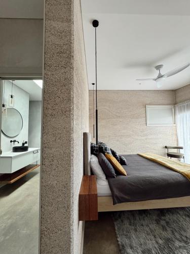 a bedroom with a large bed and a mirror at INDICA HEMP HOUSE - Multi Award Winning-Luxury-Eco designed house-lake views-hot tub-Cinema in Wilyabrup
