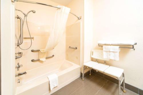 a bathroom with a tub and a shower with towels at Quality Inn & Suites Danville East in Danville