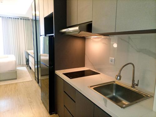 a kitchen with a sink and a counter top at Comfort Studio at 10th Floor Mataram City Apartment By Travelio in Kejayan