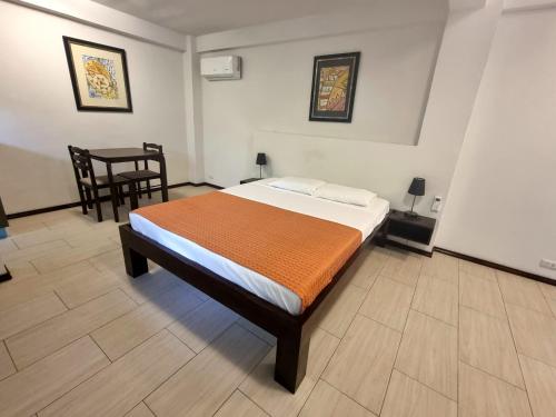 a bedroom with a bed and a table and chairs at Day & Night Accommodations in Daanbantayan