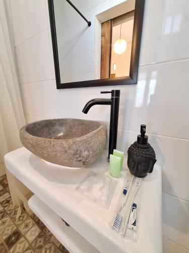 a bathroom with a stone sink on a counter at Sastro Place in Yogyakarta