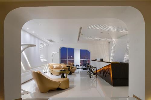 a living room with yellow chairs and a table at m58 Sky Sunset Hotel in Chongqing