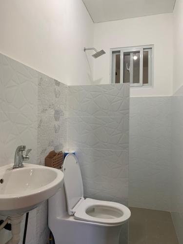 a bathroom with a toilet and a sink at Reymen's Transient in Bacolor