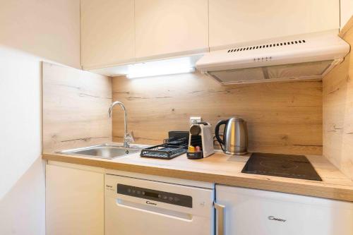 une petite cuisine avec un évier et une cuisinière dans l'établissement Matisse - Centre - Rue Piétonne - Annecy, à Annecy