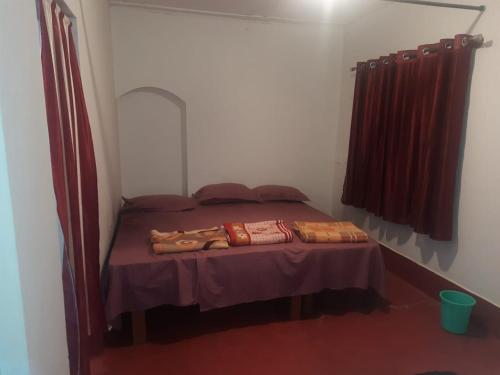a small bed in a small room with two pillows on it at Spinson Home Stay in Madikeri