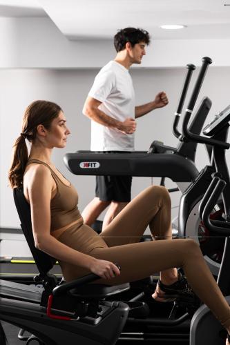 a man and woman riding on a treadmill in a gym at Athenian Riviera Hotel& Suites in Athens