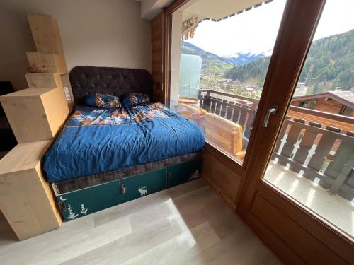a bedroom with a bed in a room with a window at Le studio de mimi in Le Grand-Bornand