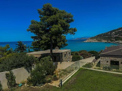 a view of the ocean from a house with a tree at Sublime villa vue mer pieds dans l'eau in Monticello