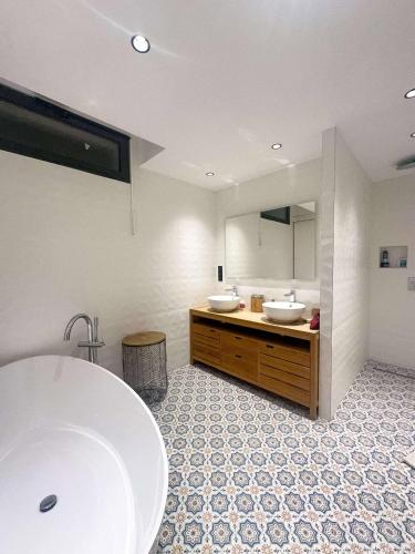 une salle de bain avec deux lavabos et un grand miroir dans l'établissement Sublime villa vue mer pieds dans l'eau, à Monticello