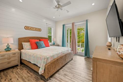 a bedroom with a bed and a dresser and a tv at Endless Summer in Anna Maria