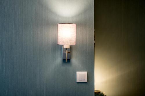 a light on a wall with a light switch at French House in Belgrade