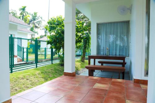 a porch with a bench and a fence at Arayaal Serviced Villa in Champakulam