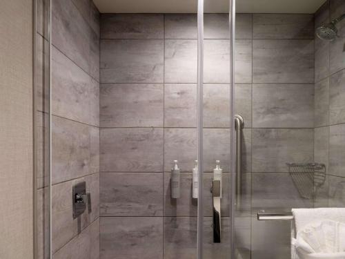 a shower with a glass door in a bathroom at Hilton Garden Inn Fredericton in Fredericton