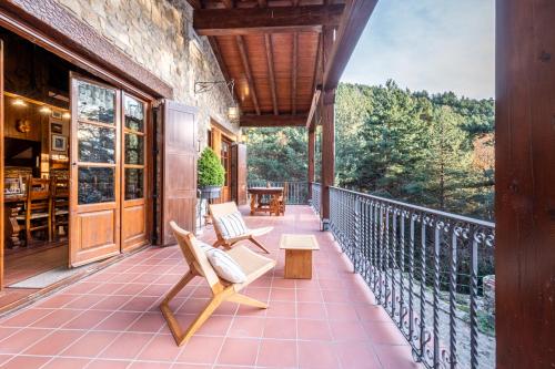 a porch with two chairs and a table at Mountain Lodge Can Campaner in Escaldes-Engordany